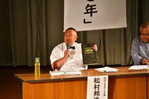 トークイベントに出演する松村邦洋さんの写真