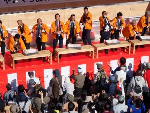 もちまきで餅をまく村岡知事の写真