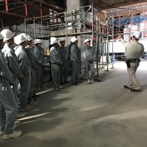 山口市新本庁舎棟新築工事現場で免振装置を見学する萩商工高校の生徒