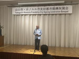山口市・ホノルル市友好都市提携記念祝賀会であいさつを述べる柳居議長