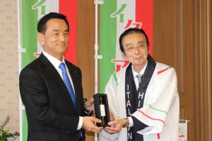 オリーブオイルを手に記念撮影する村岡知事の写真