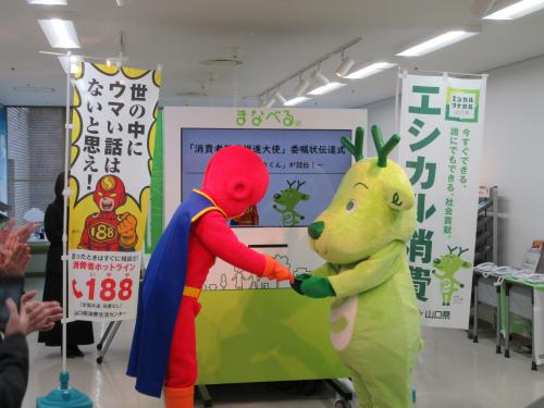 委嘱状をエシカくんに渡す188マン